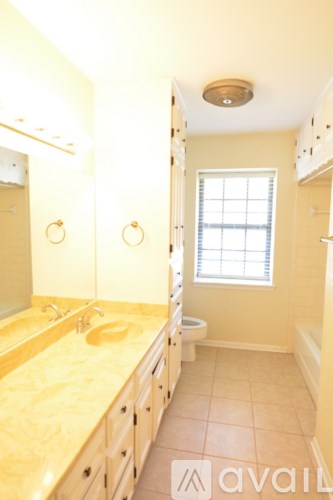 A bathroom with a sink, toilet and a window.