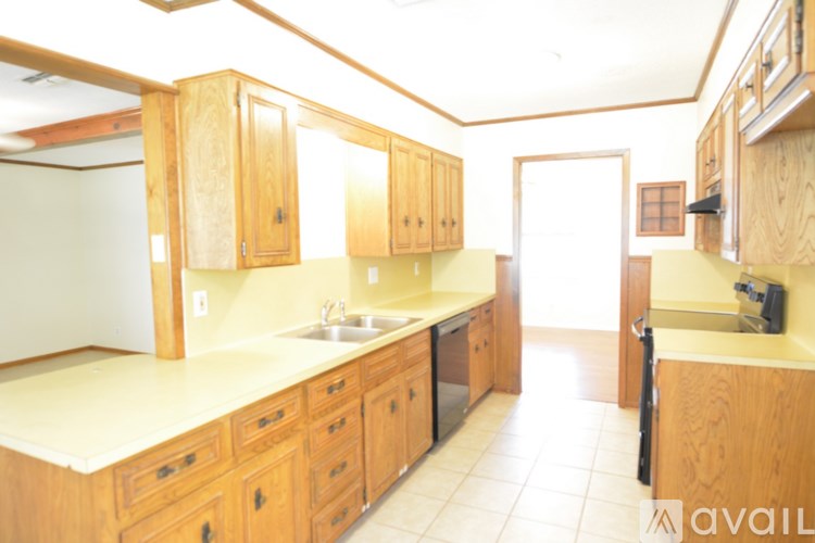 A kitchen with wooden cabinets and a white counter top.