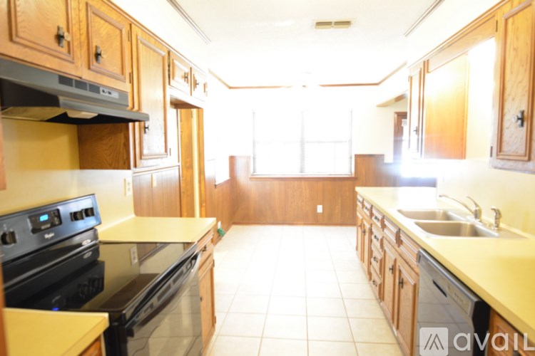 A kitchen with wooden cabinets and a black stove top oven.