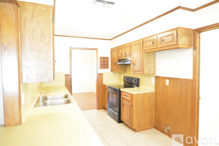 A kitchen with wooden cabinets and a stove top oven.