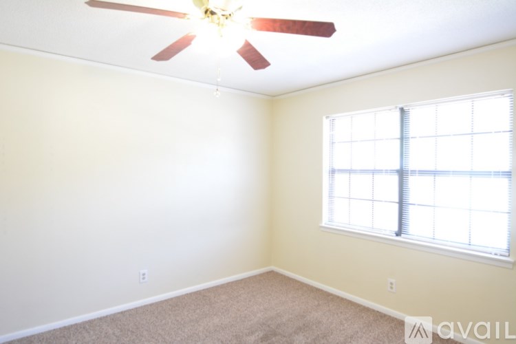 A room with a ceiling fan and a window.