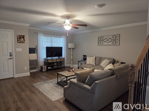 A spacious living room with a staircase leading to the upper floor.