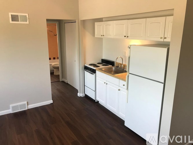A kitchen with white cabinets and a wooden floor.