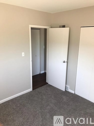 A room with a carpeted floor and two white doors.