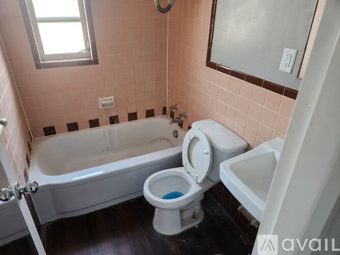 A bathroom with a toilet, tub, and sink.