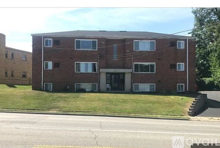 A brick building with a green lawn in front.