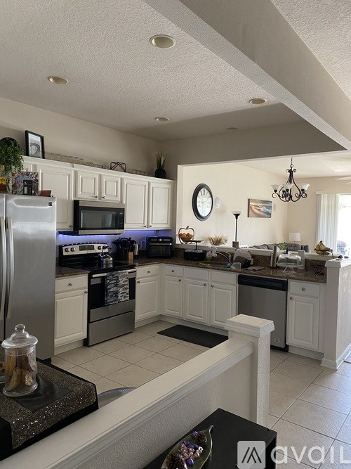 A kitchen with white cabinets and a black stove top.