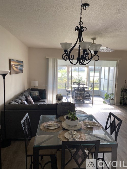 A dining room with a glass table set for two.