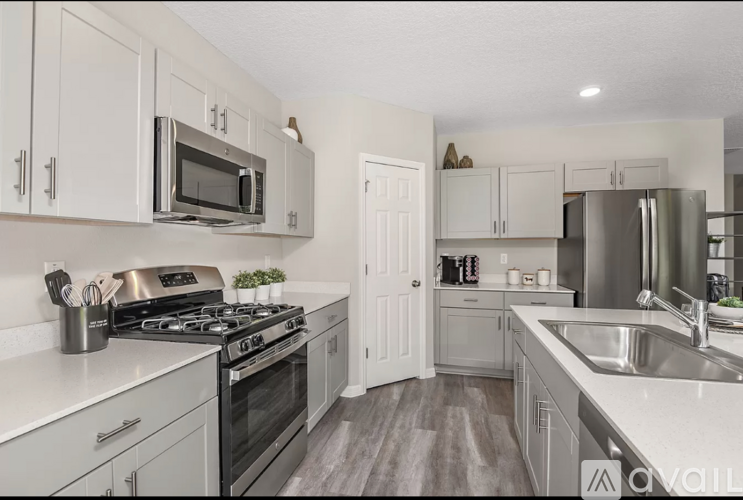 A kitchen with white cabinets and appliances.