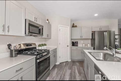 A kitchen with white cabinets and appliances.