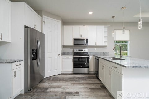 A kitchen with white cabinets and a marble countertop.