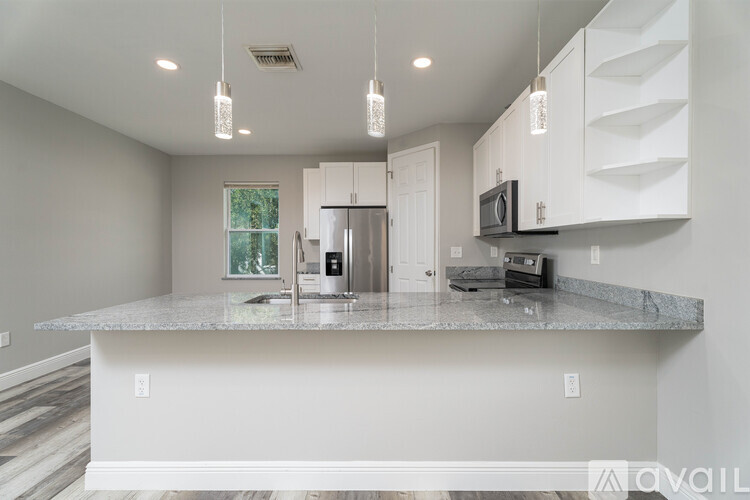 A kitchen with a granite countertop and white cabinets.