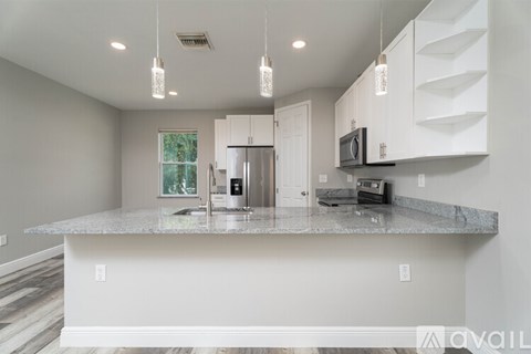 A kitchen with a granite countertop and white cabinets.