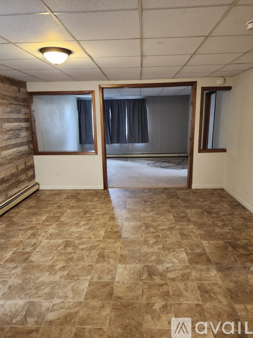 A room with a tiled floor and a window with curtains.