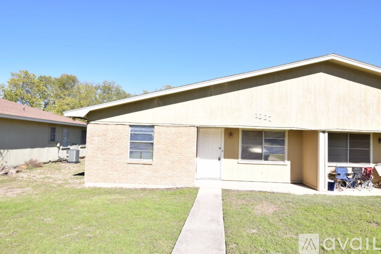 A house with a beige exterior and a white door is for sale.