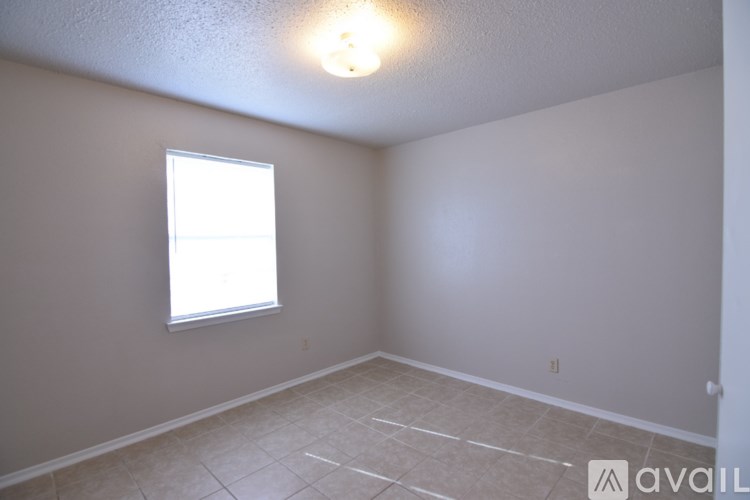 A room with a window and tiled floor.