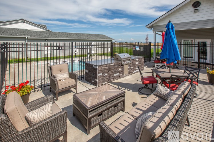 A patio with a table, chairs, and a pool.