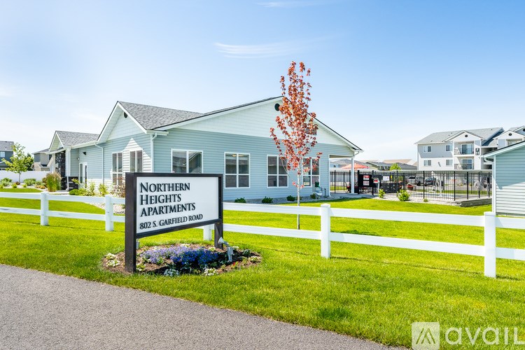 A sign for Northern Heights Apartments stands in front of a building.