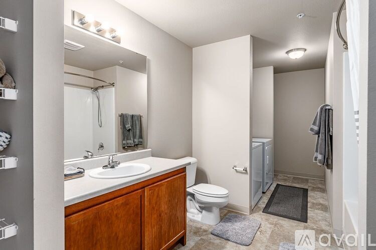 A bathroom with a toilet, sink, and mirror.