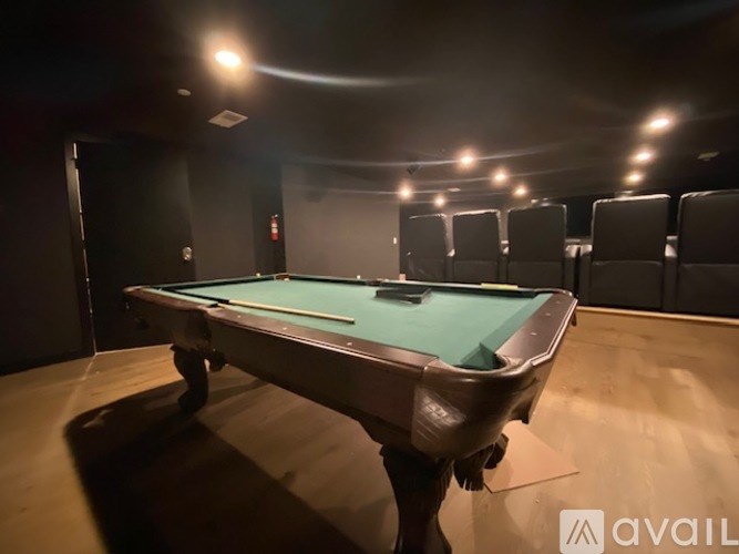 A pool table in a room with lights on the ceiling.
