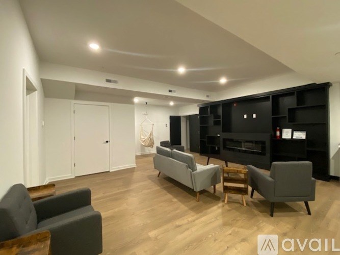 A living room with a grey couch, a black entertainment center, and a wooden floor.