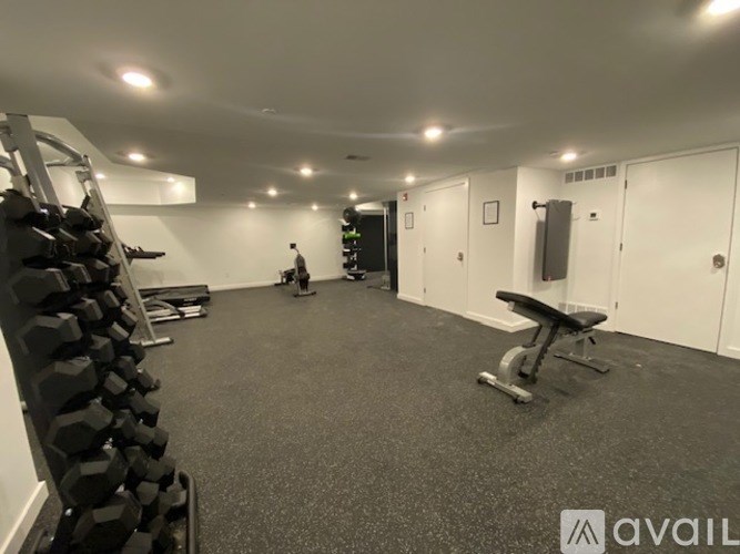 A gym with a weight rack, bench, and exercise equipment.
