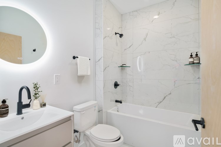 A bathroom with a marble wall and a round mirror.