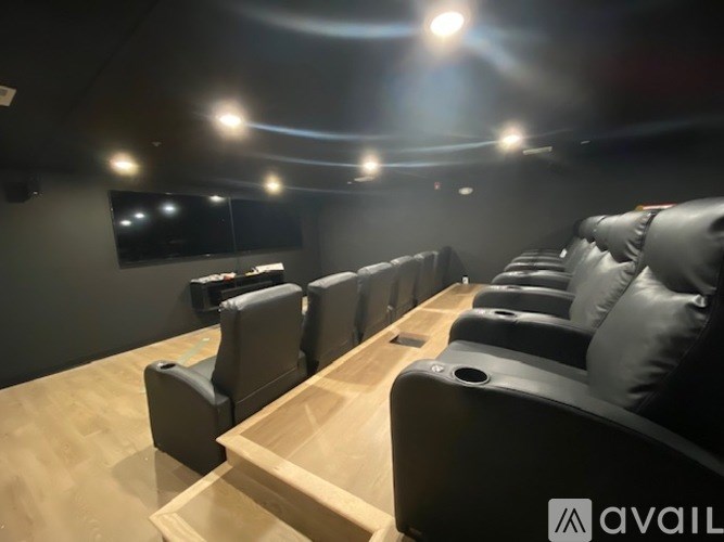 A row of black leather seats in a movie theater.