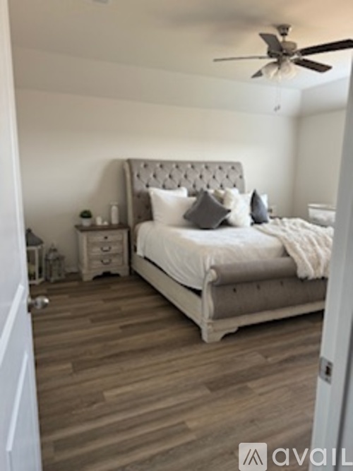 A bedroom with a large bed and a ceiling fan.