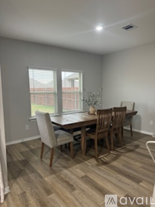 A dining room with a wooden table and chairs.
