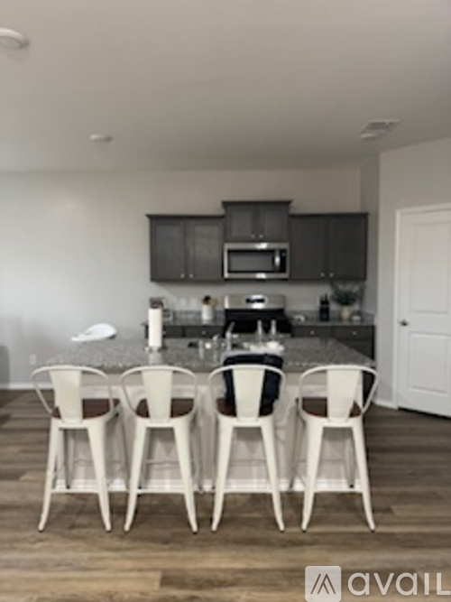Four chairs are lined up in a kitchen.