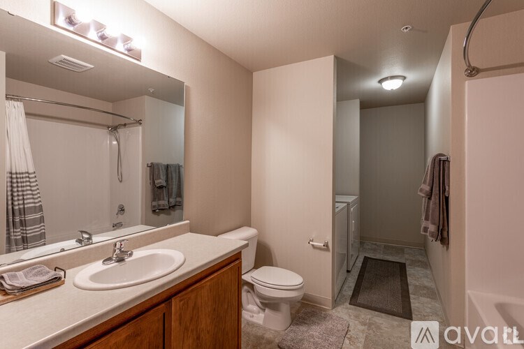 A bathroom with a sink, mirror, toilet, and shower.
