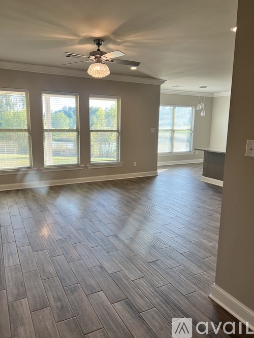 A spacious room with a ceiling fan and wood flooring.
