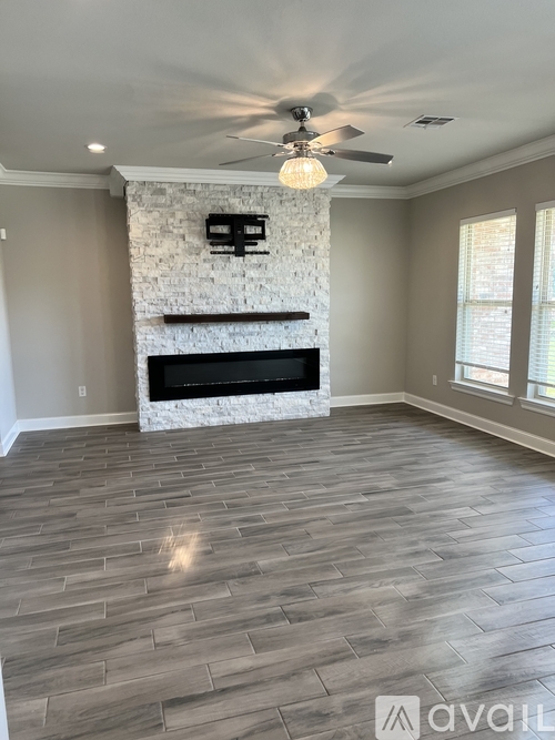 A living room with a fireplace and a ceiling fan.