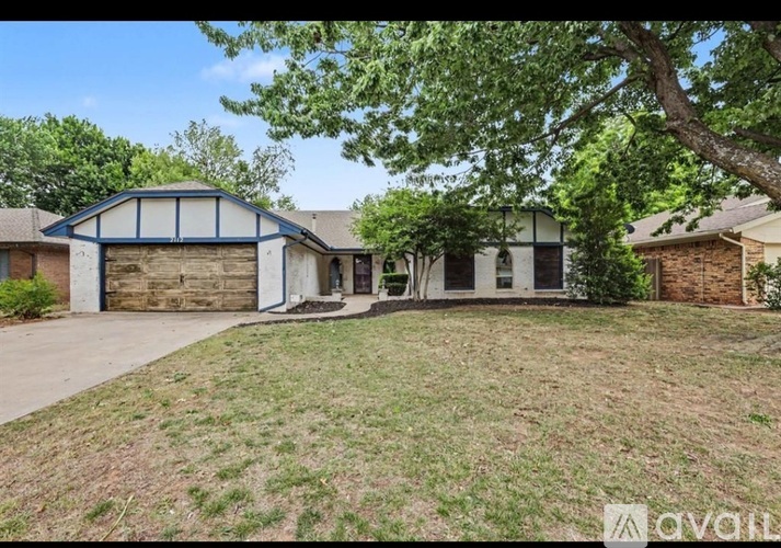 A house with a garage and a mailbox in front of it.