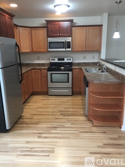 A kitchen with wooden cabinets and a refrigerator.