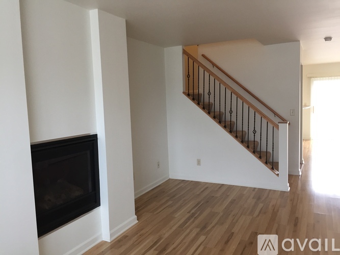 A living room with a fireplace and a staircase.