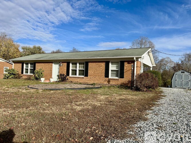 A house with a gravel driveway in front.