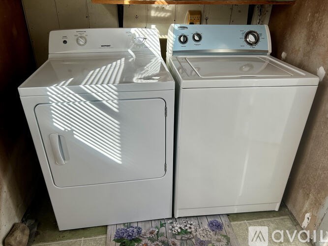 Two white washing machines are in a small room.