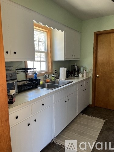 A kitchen with white cabinets and a sink.