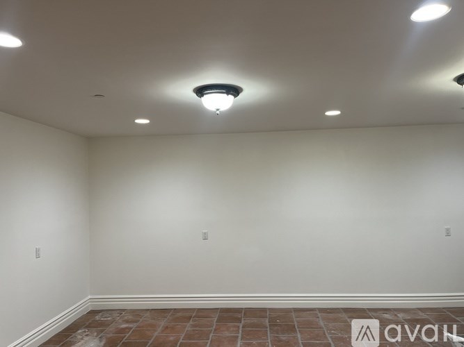 A room with a tiled floor and recessed lighting.