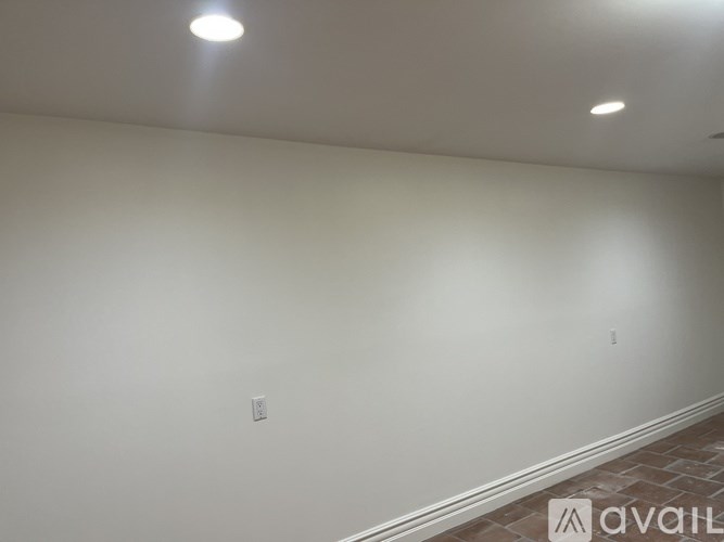 A room with a white wall and a light switch.