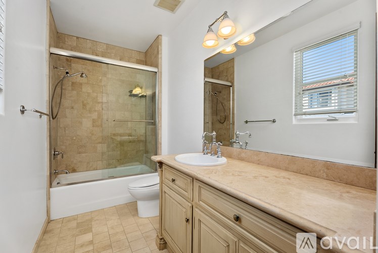 A spacious room with tiled flooring and white walls.