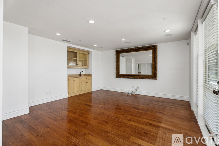 A hallway with a light fixture on the wall and a door at the end.