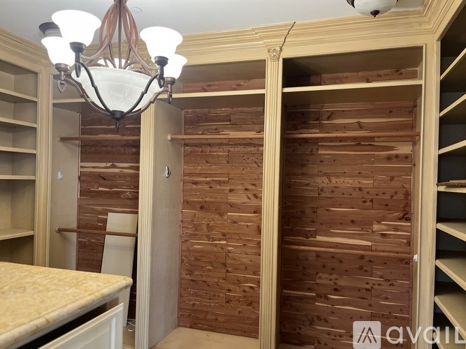 A room with a chandelier and wooden walls.