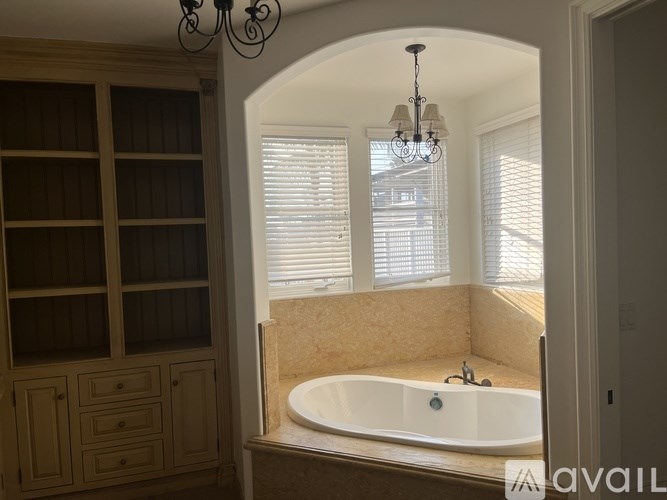 A bathroom with a large tub and a chandelier.
