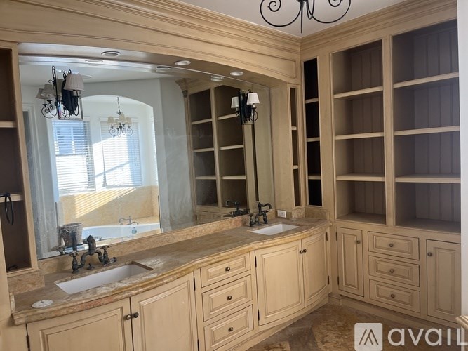 A bathroom with a large vanity and a mirror above the sink.