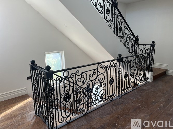 A staircase with a black wrought iron railing.