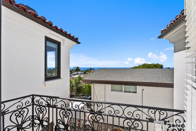 A balcony with white columns and a black railing.