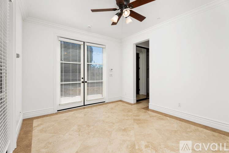 A room with a ceiling fan and a sliding glass door.